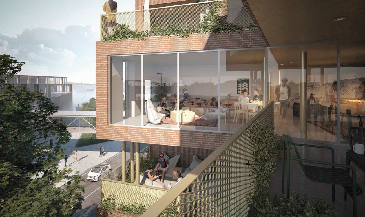 Røde murstensbygninger med glasfacader, balkoner og mennesker, moderne byliv, grønt område i baggrunden.