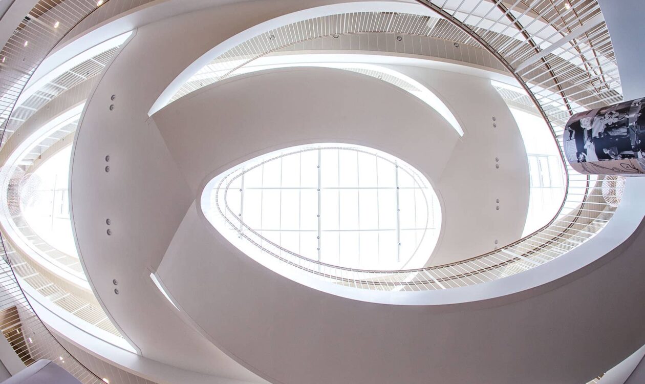 Moderne spiraltrappe med stort ovenlysvindue og rene kurver.