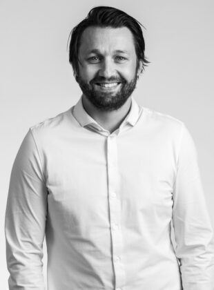 Mørkhåret mand i hvid skjorte på grå baggrund