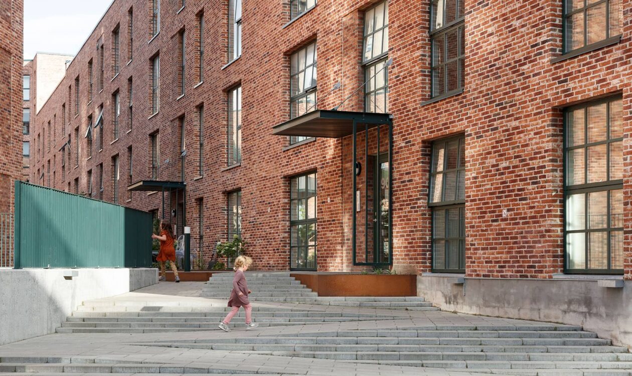 Legende børn foran rød murstensbygning på Grønttorvet