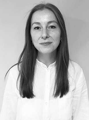 Kvinde i hvid skjorte med mørkt hår på grå baggrund