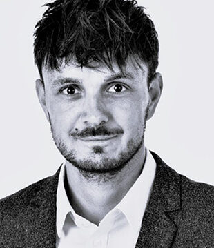 Man i hvid skjorte med grå blazer på grå baggrund