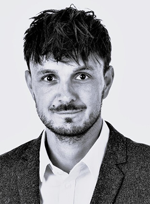 Man i hvid skjorte med grå blazer på grå baggrund