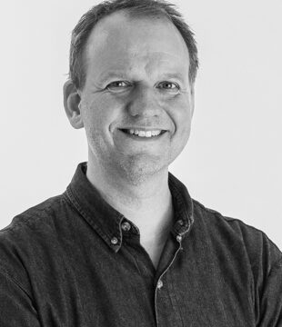 Portræt af person i mørk skjorte på grå baggrund