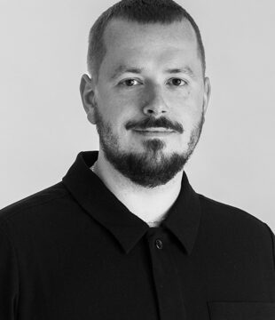 Portræt af person i sort trøje på grå baggrund.