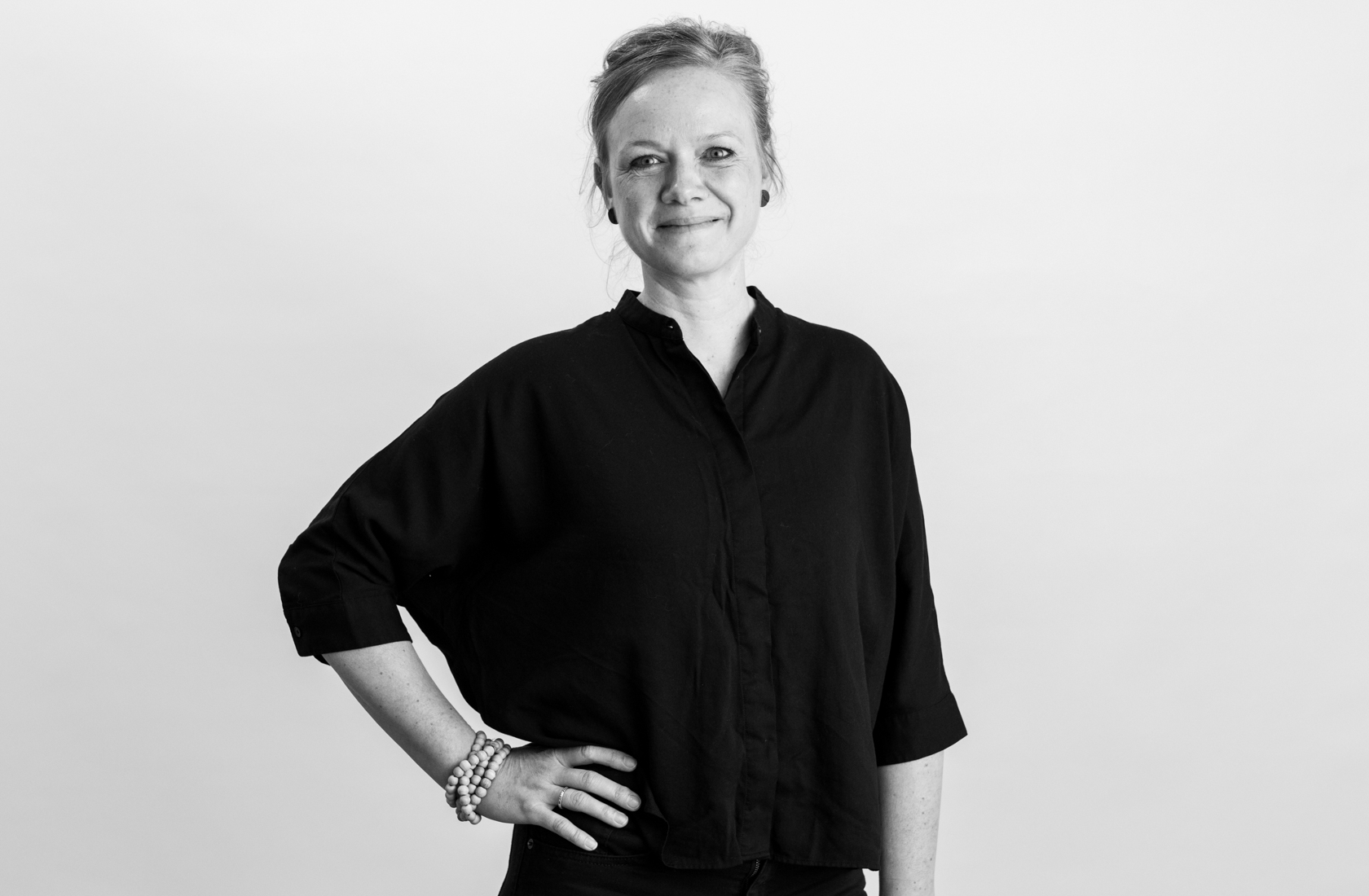 Sort-hvid portræt af person i sort skjorte med arm i siden.