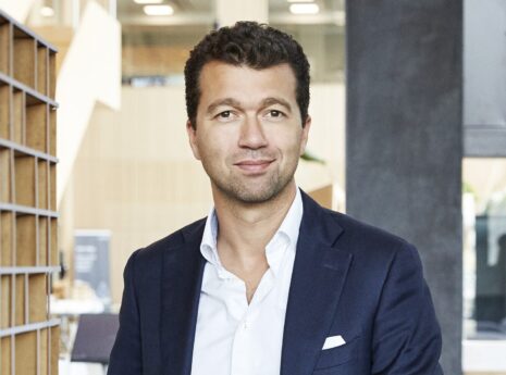 Mand i jakkesæt i moderne kontormiljø.