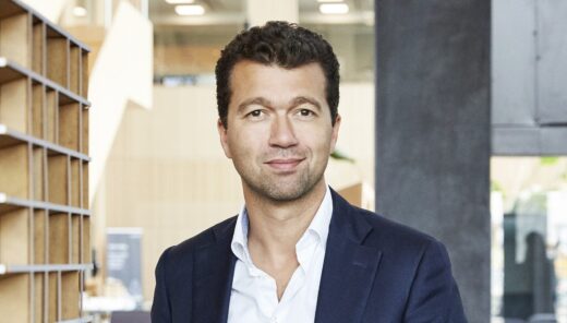 Mand i jakkesæt i moderne kontormiljø.