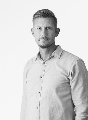 Mand i skjorte poserer i sort-hvid billede.