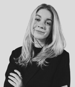 Kvinde i sort hvid med sort blazer på grå baggrund