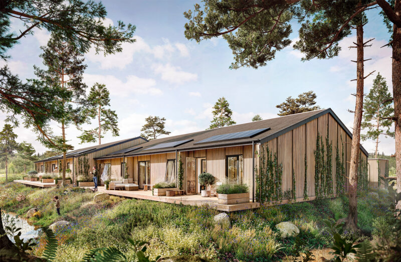 Moderne træbygninger i naturskønt område med solpaneler på taget og grønne omgivelser.