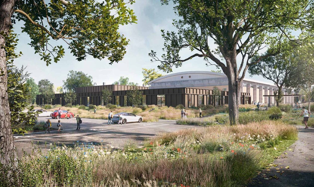 Moderne skolebygning med parkeringsplads og grønne udearealer med træer og vilde blomster