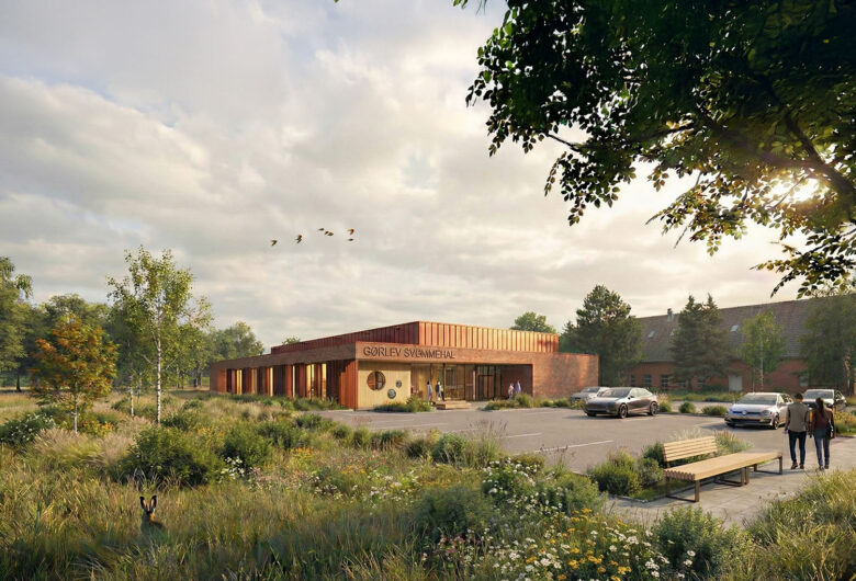Moderne svømmehal i grønne omgivelser med parkeringsplads og gående gæster