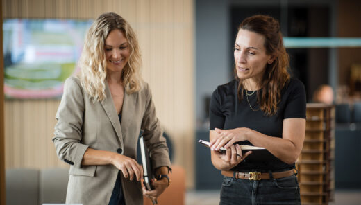 To kvindelige medarbejdere diskuterer byggeprojekt med modeller på kontor