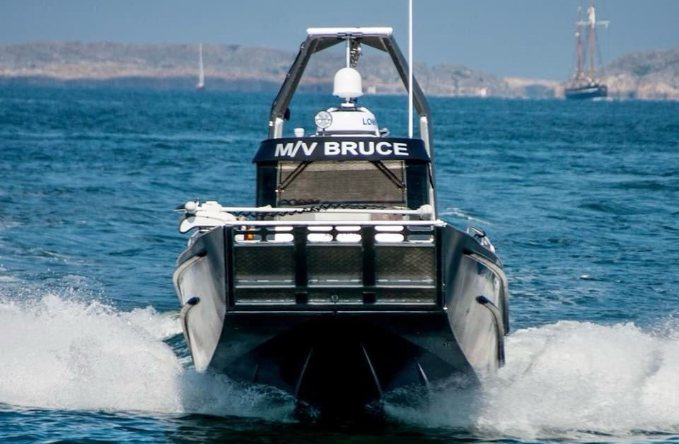 Hurtig motorbåd M/V BRUCE sejler fremad på åbent hav med bølger omkring stævnen