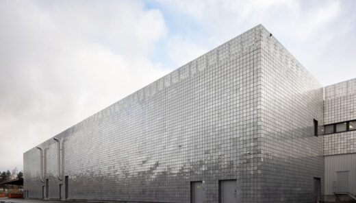 Datacenter med facade med sølvfarvede metalplader i geometrisk mønster mod mørk himmel