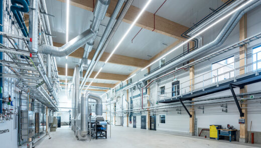 Moderne industribygning med ventilationsrør, stålkonstruktioner og højloftet produktionshal